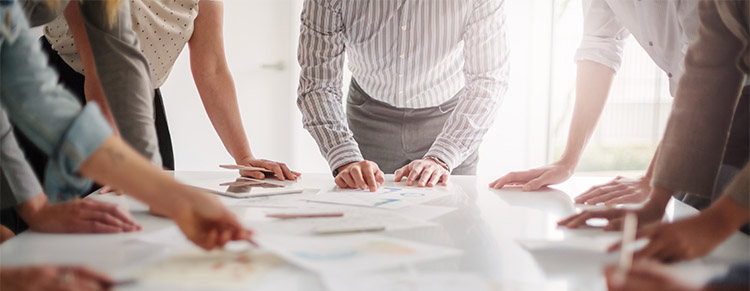 Photo of business group looking at papers on table.